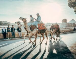 Camel riders in traditional attire at the Great Sphinx of Giza in Cairo, Egypt.