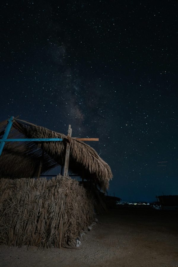 A serene night sky filled with stars over a rustic hut in Marsa Alam, Egypt.